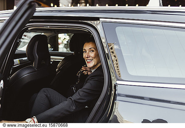 Portrait of confident female entrepreneur sitting in car