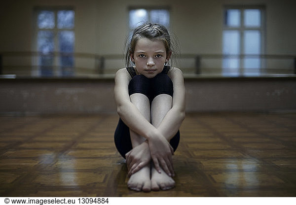 Portrait of confident girl sitting in dance studio