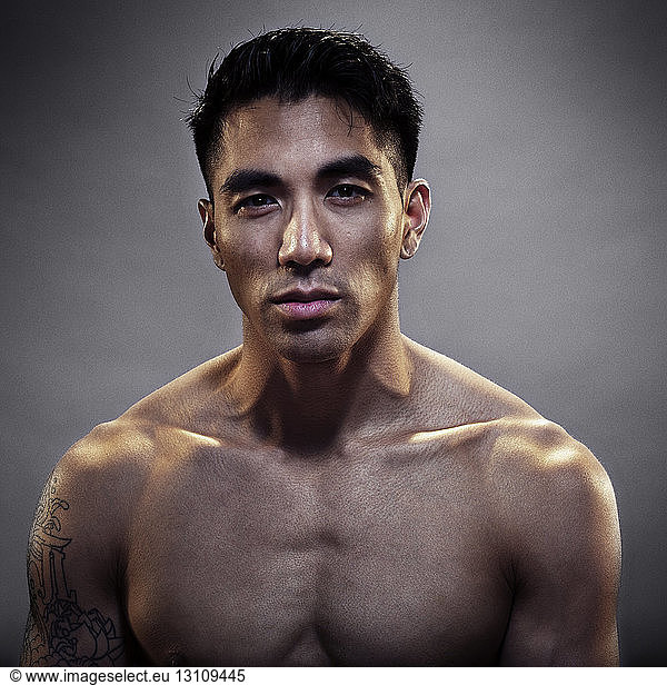 Portrait of confident kickboxer against gray background