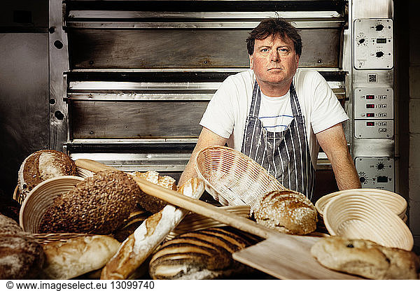 Portrait of confident male baker standing in commercial kitchen