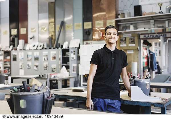 Portrait of confident male high school student in workshop