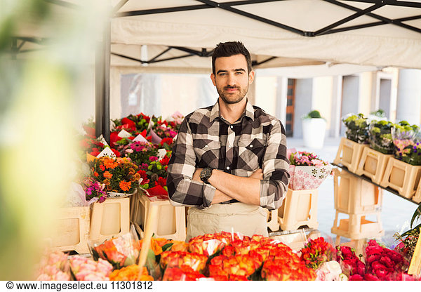 Portrait of confident male owner standing arms crossed in flower shop