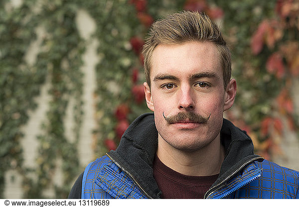 Portrait of confident man with mustache at backyard