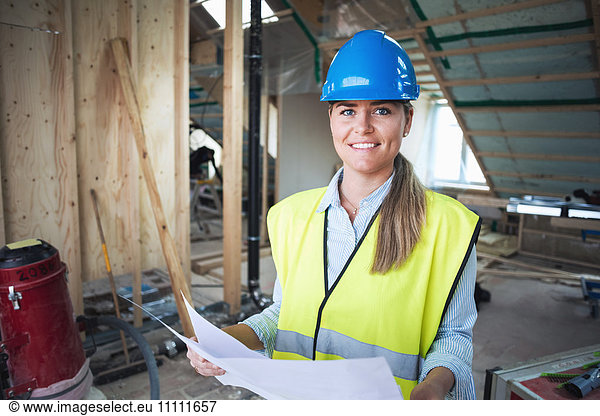 Portrait of confident manual worker analyzing document at construction site