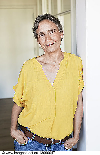 Portrait of confident mature woman standing at home