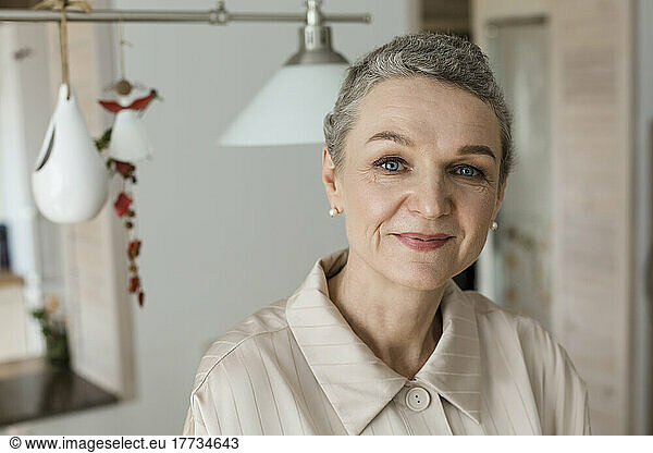 Portrait of confident mature woman with short grey hair at home