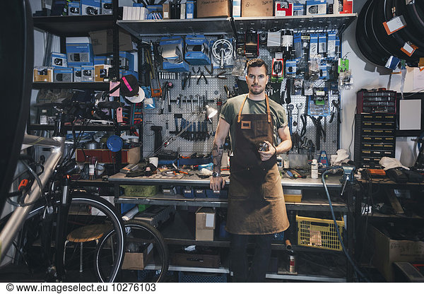 Portrait of confident mechanic at workbench