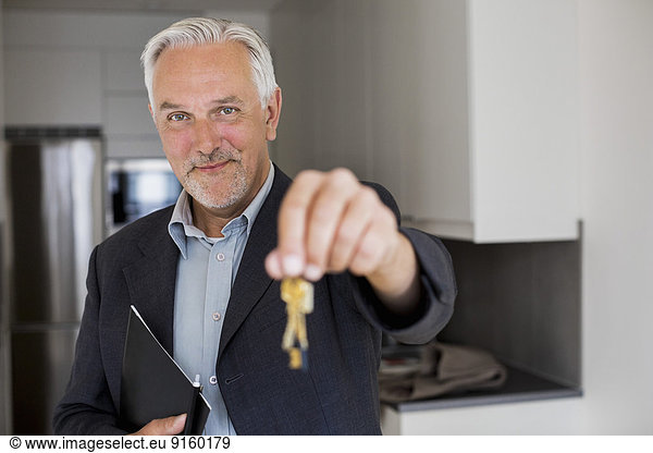 Portrait of confident real estate agent holding new house keys
