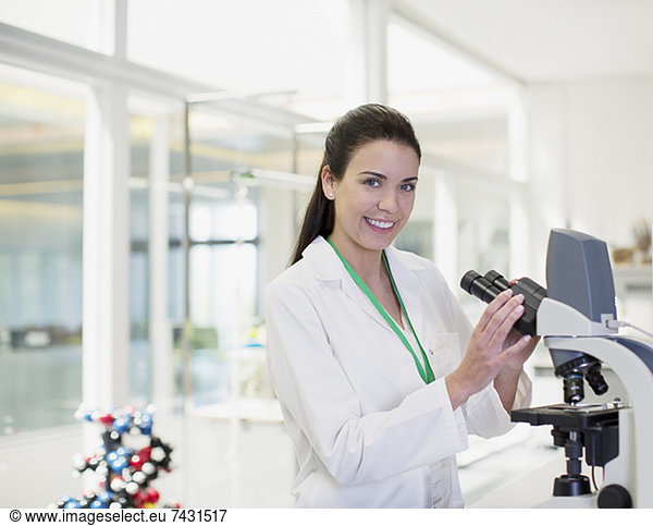 Portrait of confident scientist using microscope in laboratory