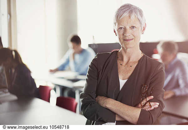 Portrait of confident senior woman in adult education classroom