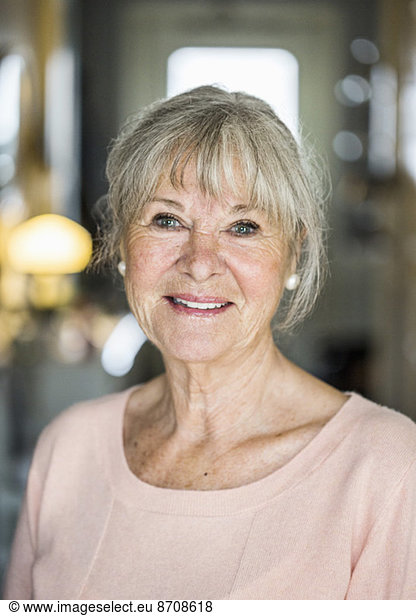 Portrait of confident senior woman smiling indoors