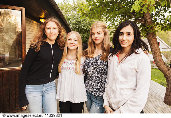 Portrait of confident teenage girls standing at yard