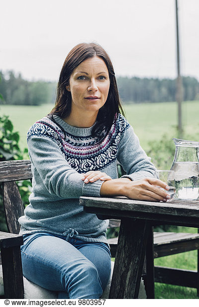 Portrait of confident woman sitting at table in organic farm