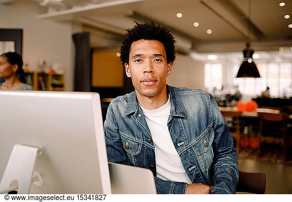 Portrait of confident young businessman sitting in office