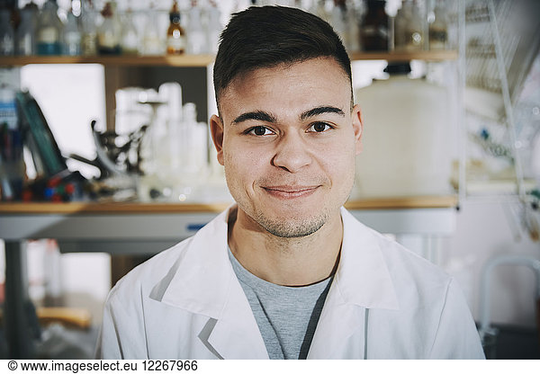 Portrait of confident young male chemistry student standing in college laboratory