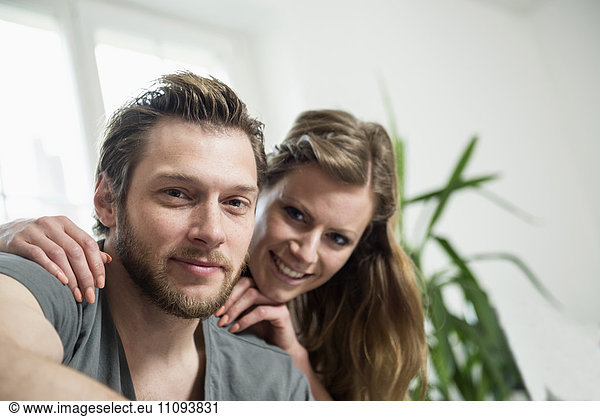 Portrait of couple in living room and smiling  Munich  Bavaria  Germany