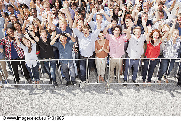 Portrait of crowd cheering with arms raised