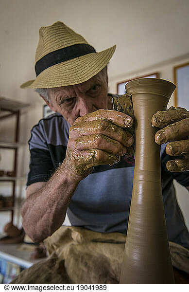 Portrait of Daniel 'Chichi' Santander shaping a vase on his potter's wheel at El Alfarero Casa Chichi workshop. Trinidad  Sancti Spiritus  Cuba.