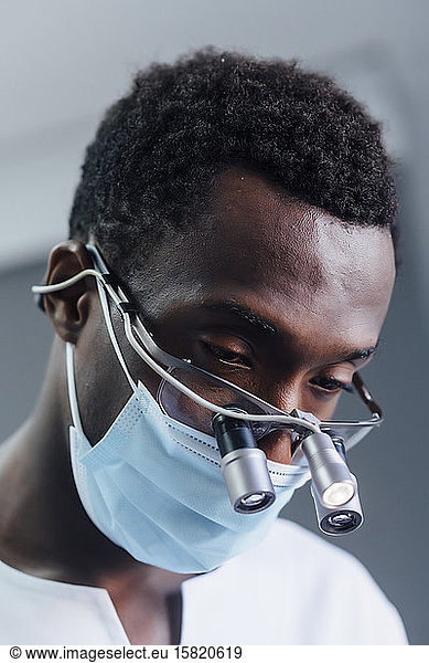 Portrait of dentist with loupe and mask in his medical practice