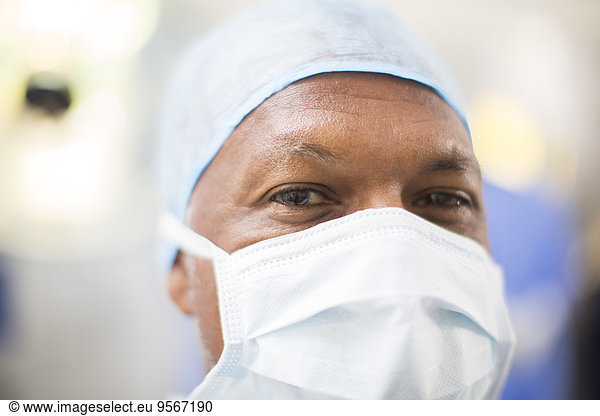 Portrait of doctor wearing surgical cap and mask in operating theater