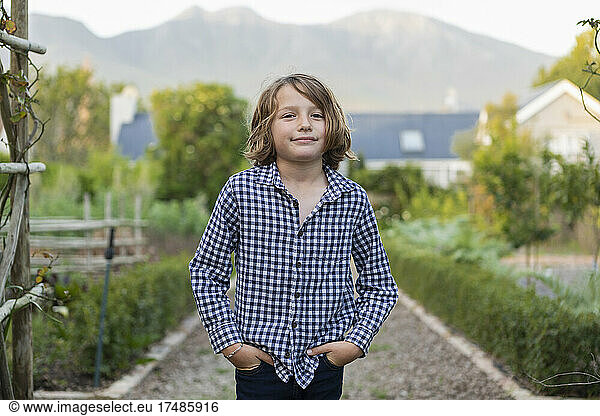 Portrait of eight year old boy smiling  hands in his pockets
