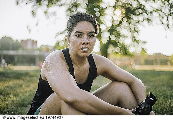 Portrait of exhausted woman sitting at park