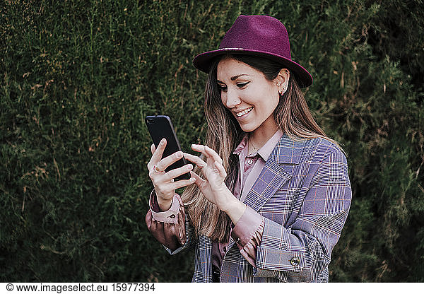 Portrait of fashionable woman using smartphone outdoors
