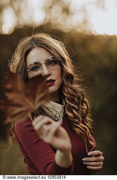 Portrait of fashionable woman with autumn leaf