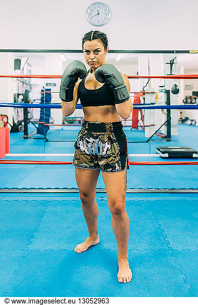Portrait of female boxer in boxing ring