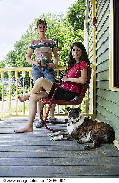 Portrait of females with dog at porch