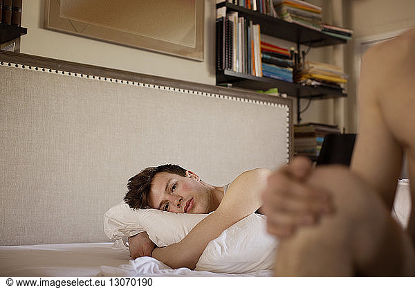 Portrait of gay man relaxing on bed at home