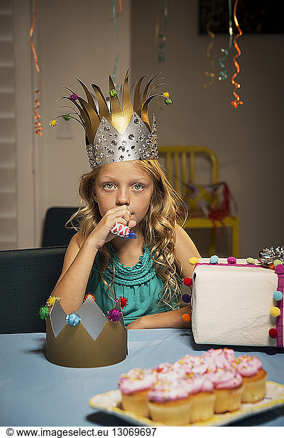 Portrait of girl holding party horn blower