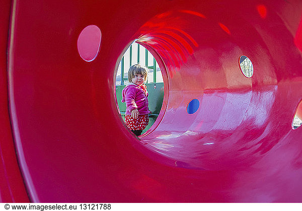 Portrait of girl seen through play equipment at park