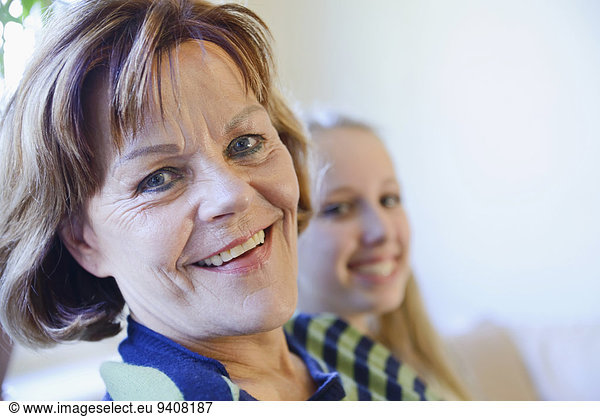 Portrait of grandmother and granddaughter  smiling  close up