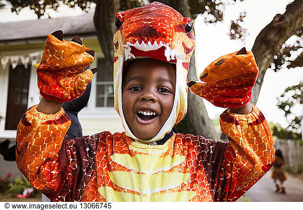 Portrait of happy boy in Halloween costume depicting dinosaur