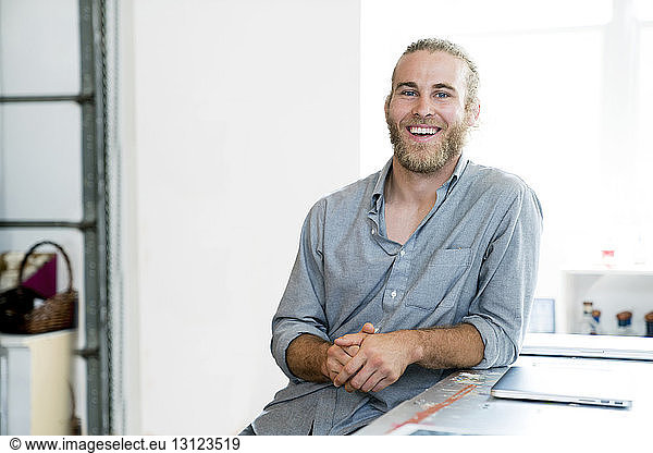 Portrait of happy businessman sitting in office