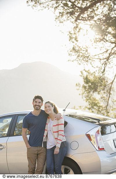 Portrait of happy couple outside car