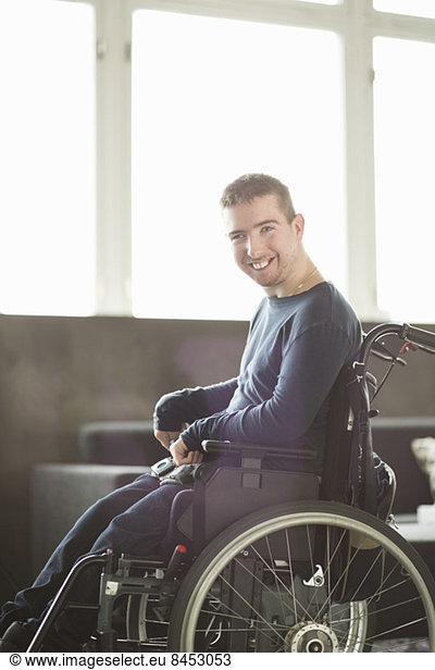 Portrait of happy disabled businessman sitting on motorized wheelchair in office