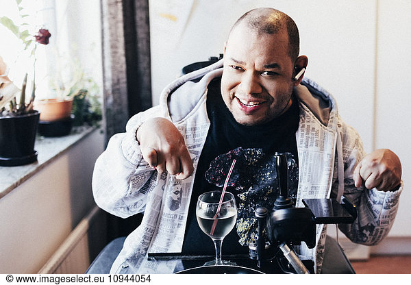 Portrait of happy disabled man with drink at recording studio