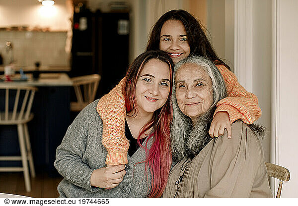 Portrait of happy family embracing in living room at home