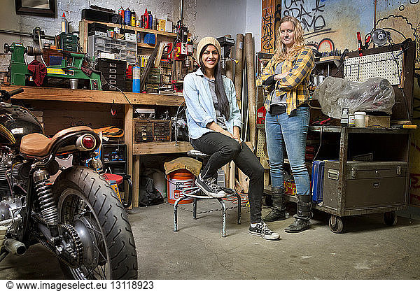 Portrait of happy female owners in auto repair shop