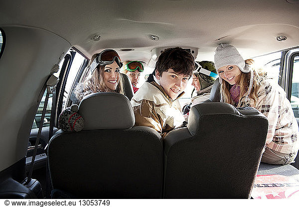 Portrait of happy friends sitting in car
