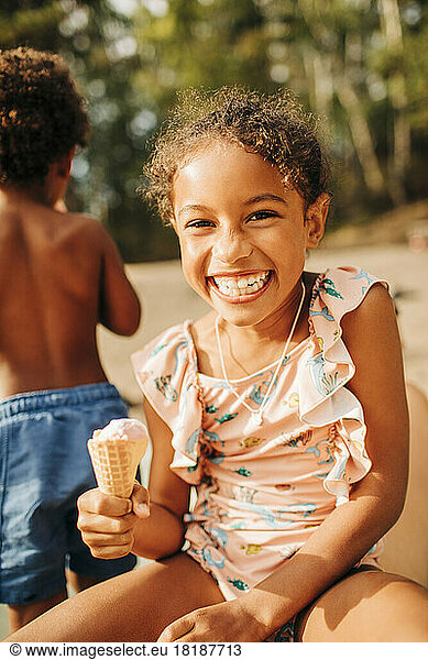 Portrait of happy girl holding ice cream on sunny day