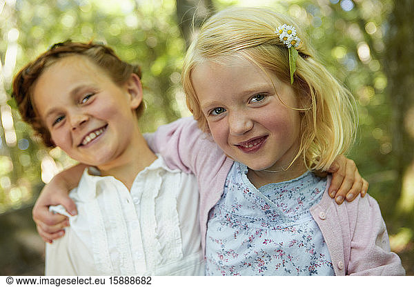 Portrait of happy girls hugging in forest