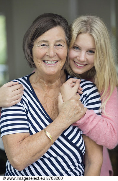 Portrait of happy grandmother and granddaughter at home