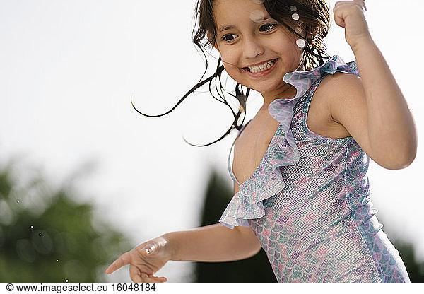 Portrait of happy little girl in swimsuit outdoors