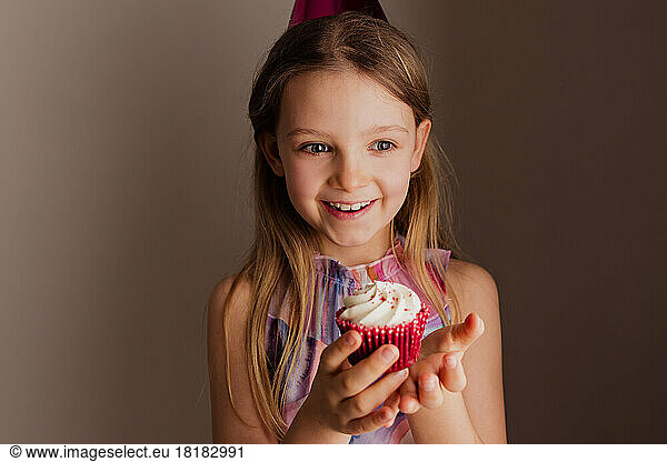 Portrait of happy little girl with cup cake