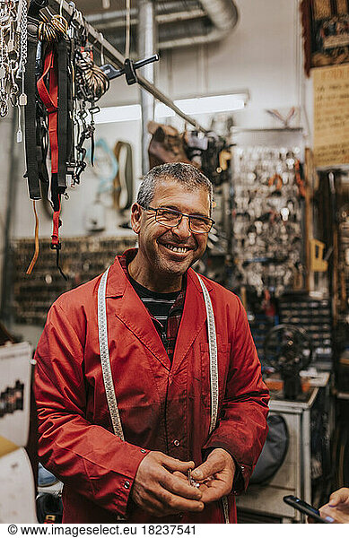 Portrait of happy male locksmith wearing eyeglasses in workshop