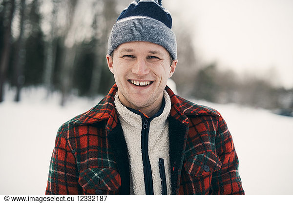 Portrait of happy man in warm clothing at park during winter