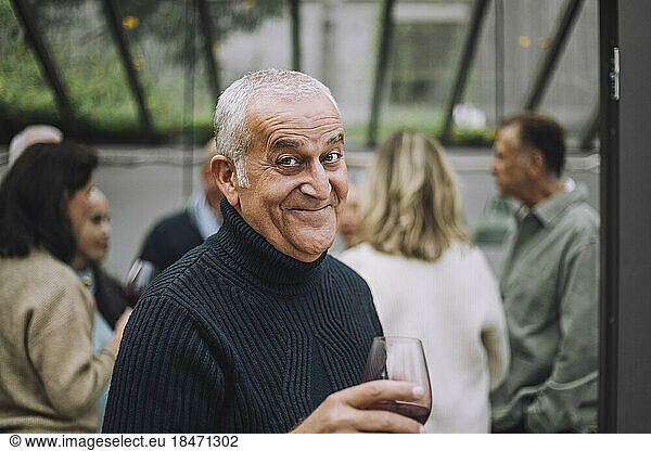 Portrait of happy mature man wearing sweater at dinner party